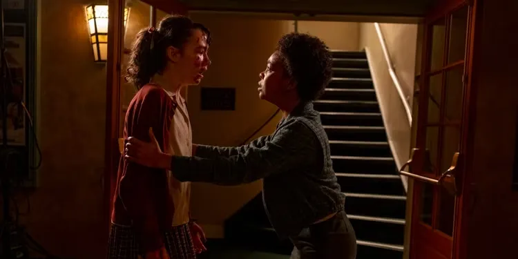 Две девушки обнимаются в помещении.